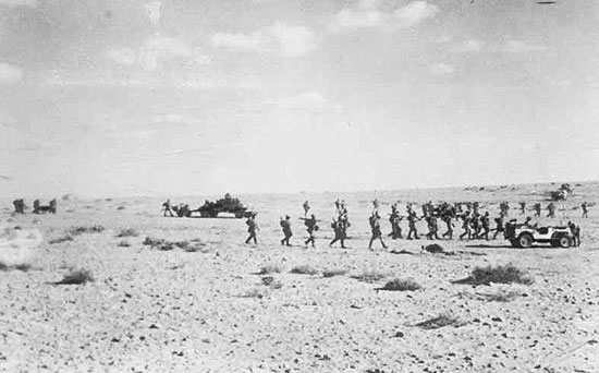 Company with 2pdr Anti-Tank guns moving up for an attack.